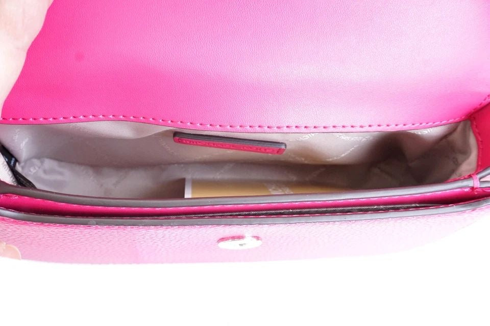 Jet Set Travel small pebbled leather crossbody bag in a fuchsia color.